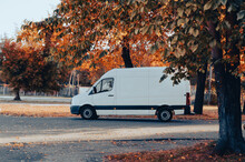 White Modern Delivery Shipments Cargo Courier Van Is Driving Between Trees. Business Distribution And Logistics Express Service.