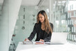 © Phushutter - Confident asian businesswoman working  in office workstation.