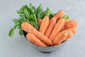 A stack of carrots in the bowl , on the marble background