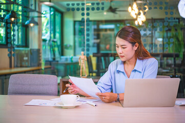 Wall Mural - Asian business woman working using  laptop for do math finance on wooden desk, tax, accounting, statistics and analytical research concept