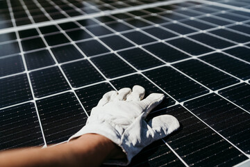 hand of mature Technician man touching solar panels on house roof for self consumption energy. Renewable energies and green energy concept