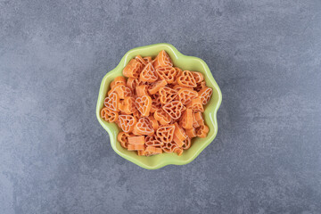 Wall Mural - Raw heart-shaped pasta in green bowl