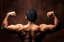 Brown Muscular Man Flexing Back Muscles Showing His Strong Triceps