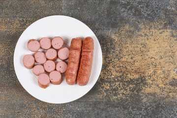 Grilled sliced sausages on white plate