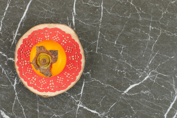 Wall Mural - Persimmon on pink napkin over wooden plate