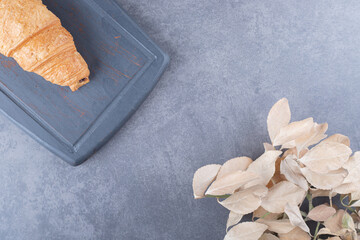 Wall Mural - Freshly baked yummy Croissant on wooden board. close up