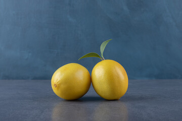 Wall Mural - Close up photo of two fresh lemon on grey background