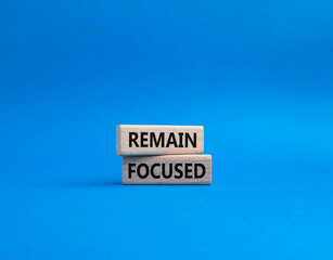 Remain focused symbol. Concept words Remain focused on wooden blocks. Beautiful blue background. Business and Remain focused concept. Copy space.