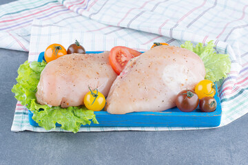 Two chicken fillets on blue plate