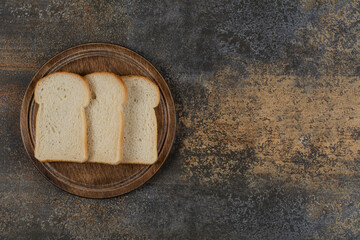 Homemade white bread slices on wooden board