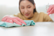 © Pormezz - happy Female housekeeper service worker wiping table surface by cleaner product to clean dust.