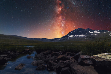Wall Mural - Beautiful night landscape. Small lake and mountains on the bright milky way galaxy. Starry night.