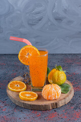 Wall Mural - Fresh tangerine juice and fruits on wooden plate