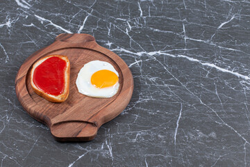 Wall Mural - Jam bread and fried eggs on the wooden plate , on the marble background