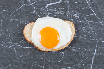 Wall Mural - Fried eggs on the sliced bread , on the marble background