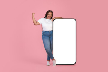 Wall Mural - Black Woman Posing Near Huge Smartphone Gesturing Yes, Pink Background