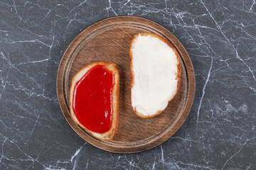 Wall Mural - Cheese and jar on two slices of bread on the board , on the marble background