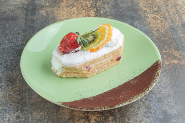 Wall Mural - A delicious eclair with fruits on a green plate