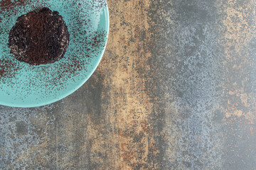 Wall Mural - A chocolate cake with cocoa powder on a blue plate