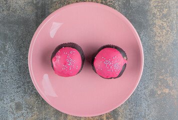 Wall Mural - Two sweet chocolate doughnuts with pink frosting and sprinkles