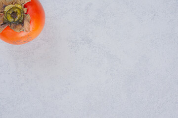 Wall Mural - Wide angle ripe orange persimmon on grey background