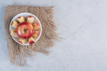 Wall Mural - wide angle photo of Apple slices and whole apple in white bowl