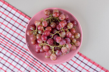 Wall Mural - Platter of grapes on a towel on marble background