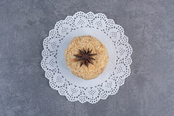 Wall Mural - Piece of homemade cake decorated with clove on marble surface