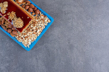 Wall Mural - Slice of caramel cake with nuts on blue plate