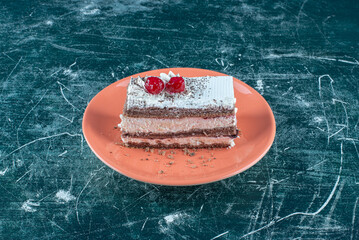 A piece of delicious cake with berries on a orange plate