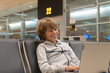 © servando - Blond boy waits in an airport lounge while using his laptop computer.