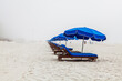 Blue Beach Loungers  A foggy day on the beach leaves these beach lounger chairs ready but vacant.  Gulf Shores Alabama  