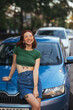 © teksomolika - Beautiful girl sits on the hood of a blue car