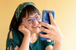 Portrait of a girl with down syndrome.Portrait of a girl with down syndrome talking on a cell phone. Cute smiling down syndrome girl wearing casual clothes, glasses very happy.