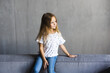 © F8  \ Suport Ukraine - Small little girl sitting on a comfortable sofa in the family room