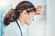© C Coetzee/peopleimages.com - Sad, stress and burnout with doctor against window with headache from healthcare, medical or nurse. Mental health, depression and anxiety with woman working in hospital while tired, fear and fail