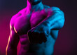 © oleg_ermak - Sportive man bodybuilder shows fist in the colorful neon light with naked muscular torso, abdominal muscles in neon studio light focus on the fist