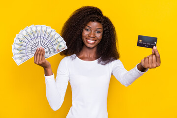 Poster - Photo of pretty positive person arm hold demonstrate plastic debit card dollar banknotes isolated on yellow color background