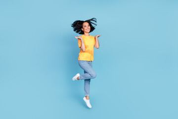 Wall Mural - Full body portrait of overjoyed adorable lady jumping good mood isolated on blue color background