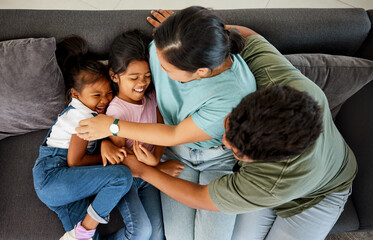 Canvas Print - Comic family, happy sofa and parents with love for children on living room couch, tickling for comedy and smile together in lounge. Girl kids laughing while playing with mother and father from above