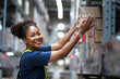 © NaruFoto - African American warehouse worker take flat box from shelf in big warehouse factory, Online shopping store for logistic service to deliver the shipment, check barcode before passing to transportation