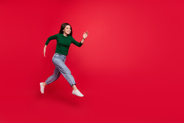 Sticker - Full body photo of cheerful cute woman model run speed hurry buyer dressed stylish green clothes isolated on vivid red color background