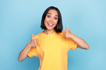 Wall Mural - Photo portrait of nice young lady korean show double thumb up excited smile wear trendy yellow outfit isolated on blue color background