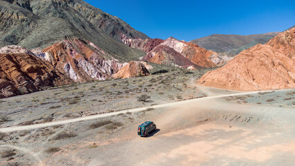 Wall Mural - A 4x4 campervan next to mountains of 7 colors. Next to Purmamarca, Los Colorados in the Argentine Puna.