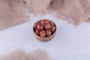 Wall Mural - Dried sour cherry plums inside a dish isolated on concrete background