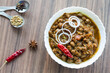 Closeup view of Pindi Chole or Pindi Chana Masala on a dark wooden background. Street food of Delhi,India and Pakistan, it is eaten with kulcha or naan. 