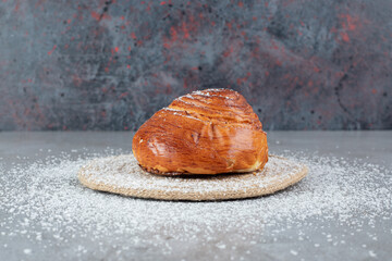 Wall Mural - Coconut powder covered trivet under a sweet bun on marble background