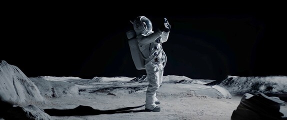 Wall Mural - Astronaut searching for cellular or wi-fi signal while walking on Moon surface