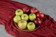 Two different apple types on a tray on marble background