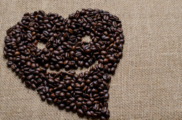 Wall Mural - The heart shape of coffee beans with smile face on hessian sack, Love coffee concept